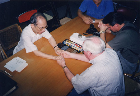 Ken praying with head of underground church in China
